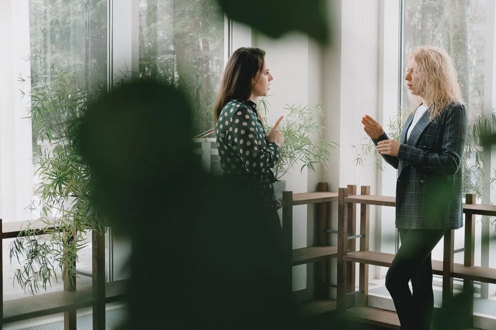 Two colleagues talking in a bright office.