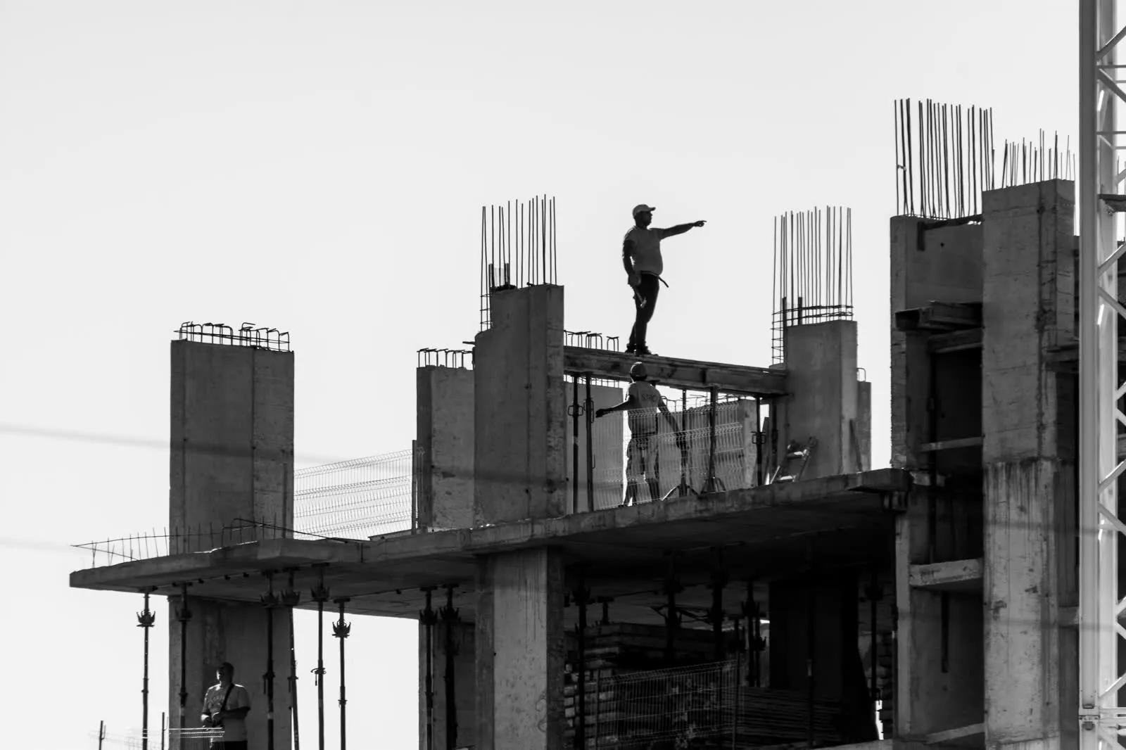 Silhouettes of construction workers on a building site.